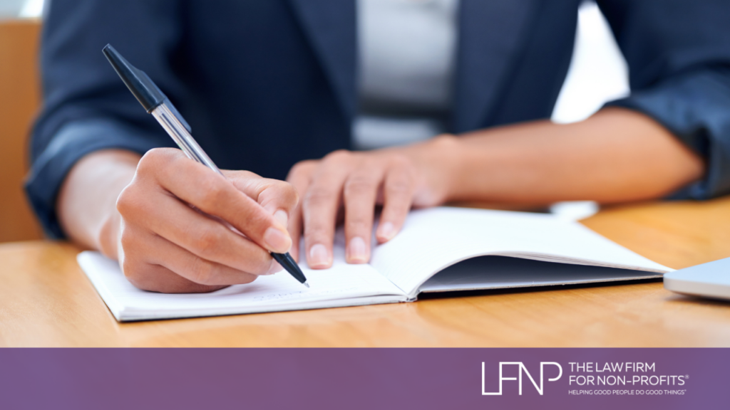 nonprofit 501c3 boardmember taking minutes and writing notes during board meeting.